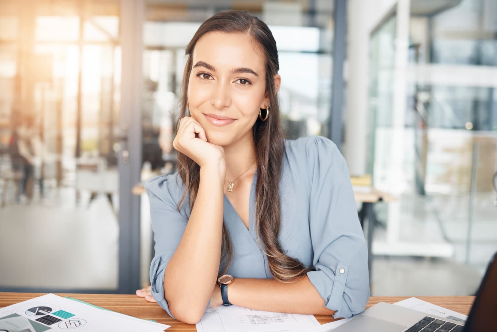 Woman at a desk with a laptop and printed documents